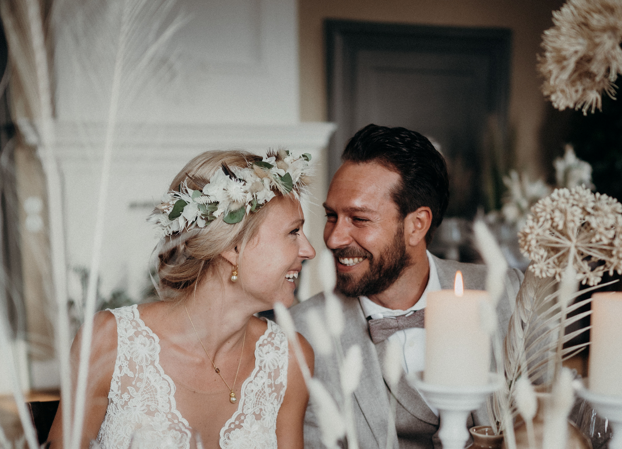 Glückliches Brautpaar umgeben von Trockenblumen. 
