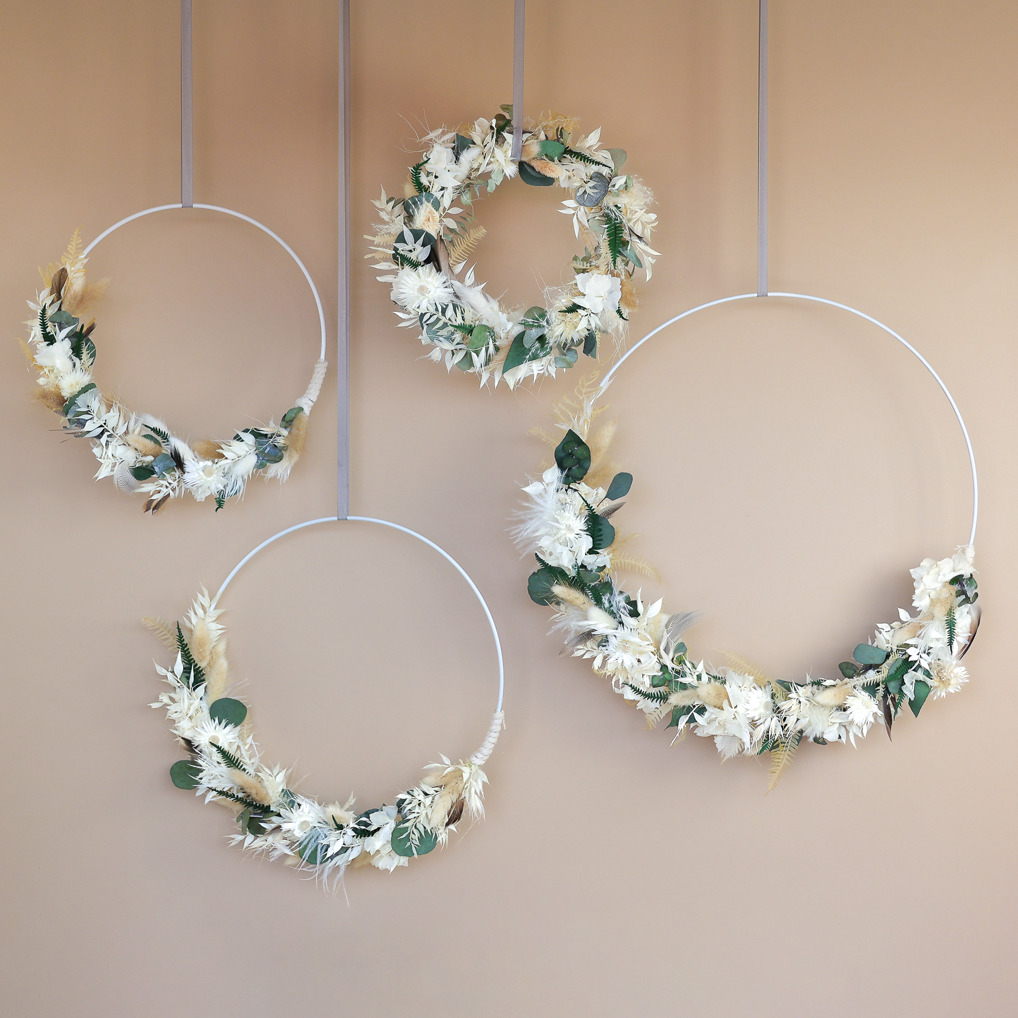 Vier Loops in verschiedenen Größen mit Trockenmaterialien in weiß, grün und beige.