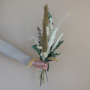 Handgefertigter Trockenblumenstrauß mit Trockenblüten in Naturtönen. Darunter Lagurus, Hortensie, Eukalyptus, Pampasgras, Capblume, Phalaris und Federn.